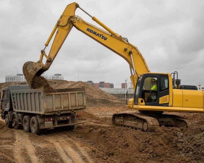 экскаватор Komatsu грузит грунт на стройплощадке