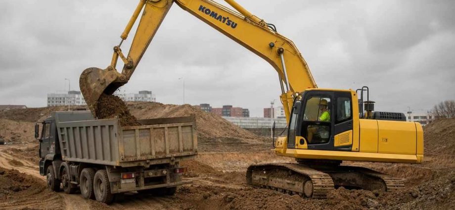 экскаватор Komatsu грузит грунт на стройплощадке