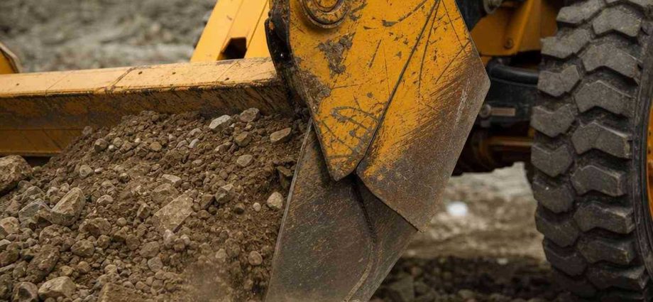 ковш фронтального погрузчика JCB в грунте на стройке