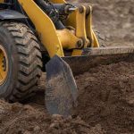 фронтальный погрузчик Komatsu загружает грунт ковшом