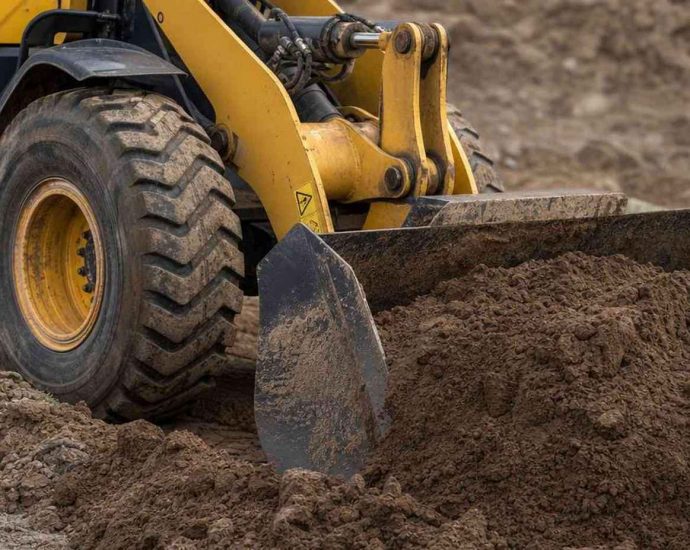 фронтальный погрузчик Komatsu загружает грунт ковшом