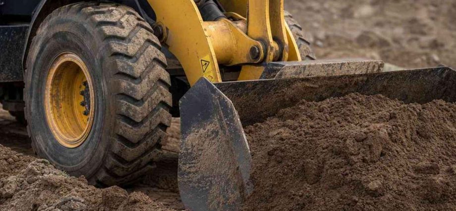 фронтальный погрузчик Komatsu загружает грунт ковшом