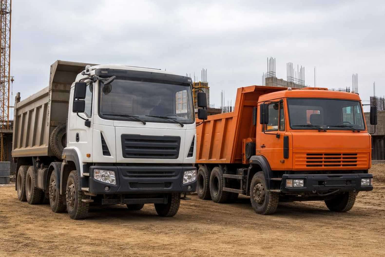 Линейка самосвалов Scania разных серий на строительной площадке