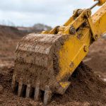 ковш экскаватора Komatsu крупным планом в грунте