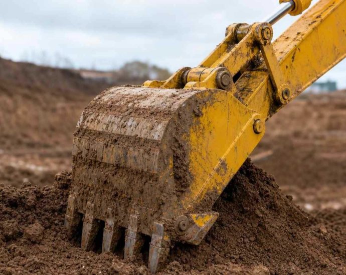 ковш экскаватора Komatsu крупным планом в грунте