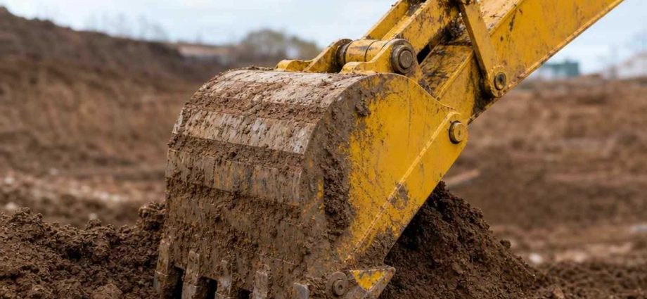ковш экскаватора Komatsu крупным планом в грунте