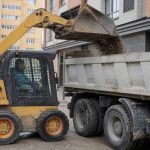 Мини-погрузчик skid-steer на стройплощадке с ковшом