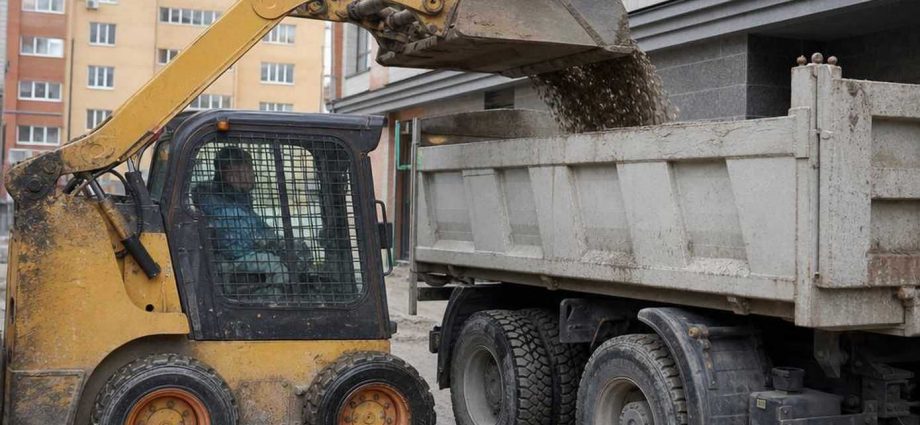 Мини-погрузчик skid-steer на стройплощадке с ковшом
